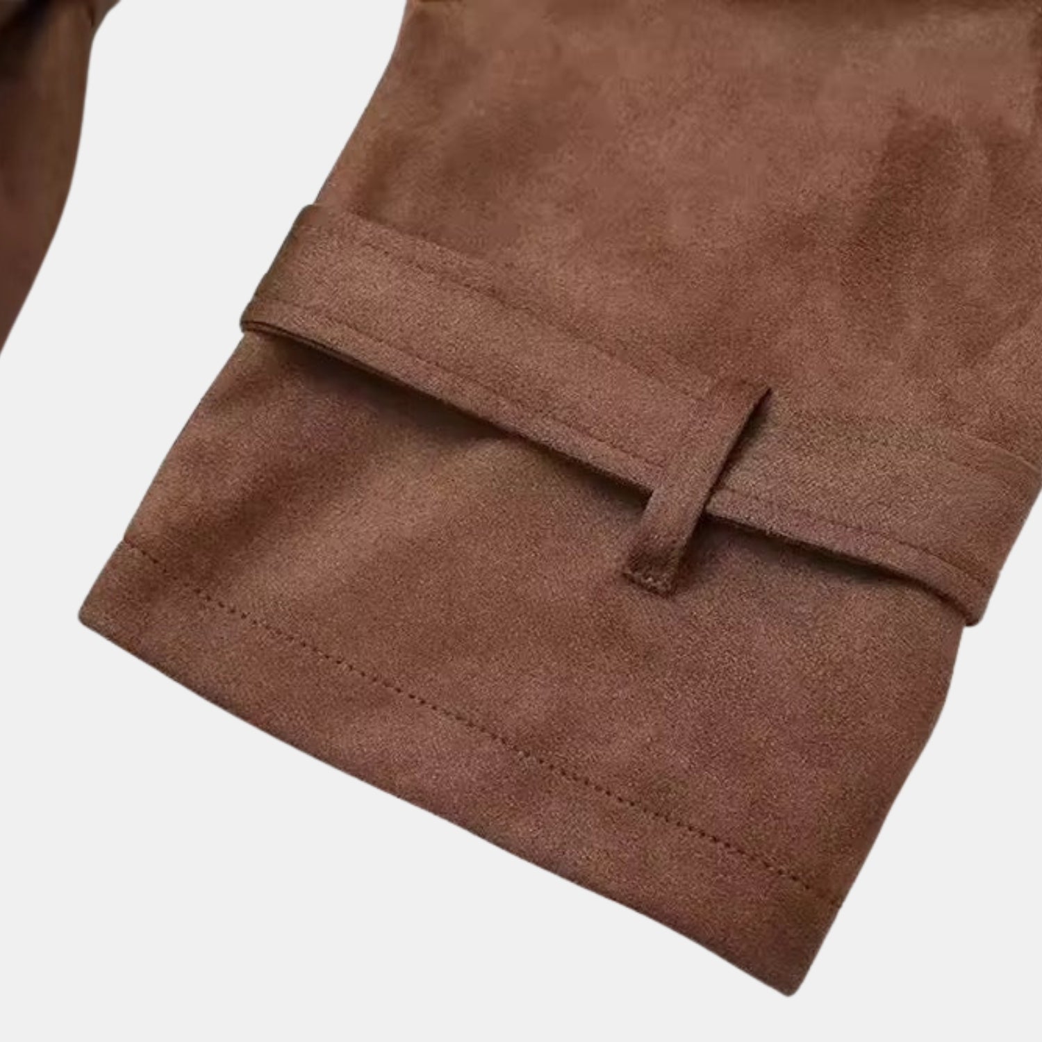 Detailaufnahme des braunen Premium Wildleder-Trenchcoats für Damen: Ärmelmanschette mit verstellbarem Riegel und feiner Naht auf weichem Wildleder.