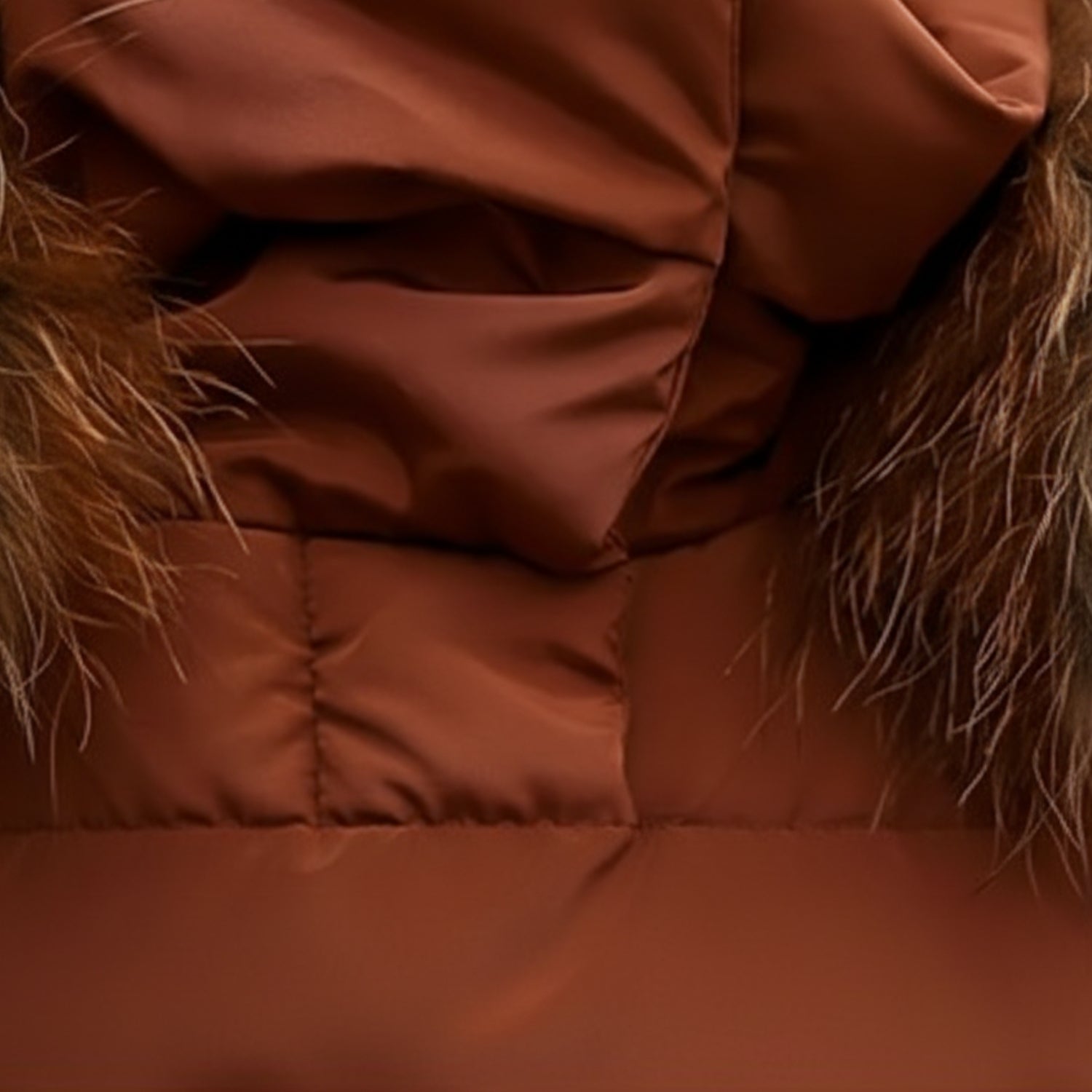 Detailansicht des warmen, bauschigen Wintermantels für Damen in Rostbraun – Nahaufnahme von Kapuze, Stehkragen und Kunstfellbesatz